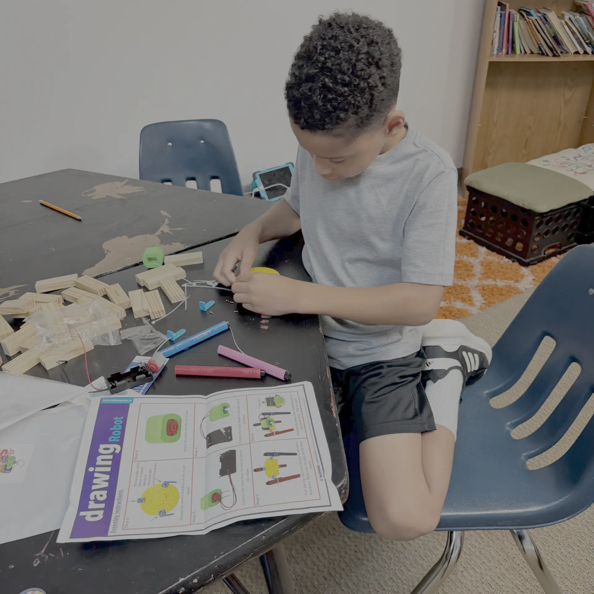 Student assembling a drawing robot kit